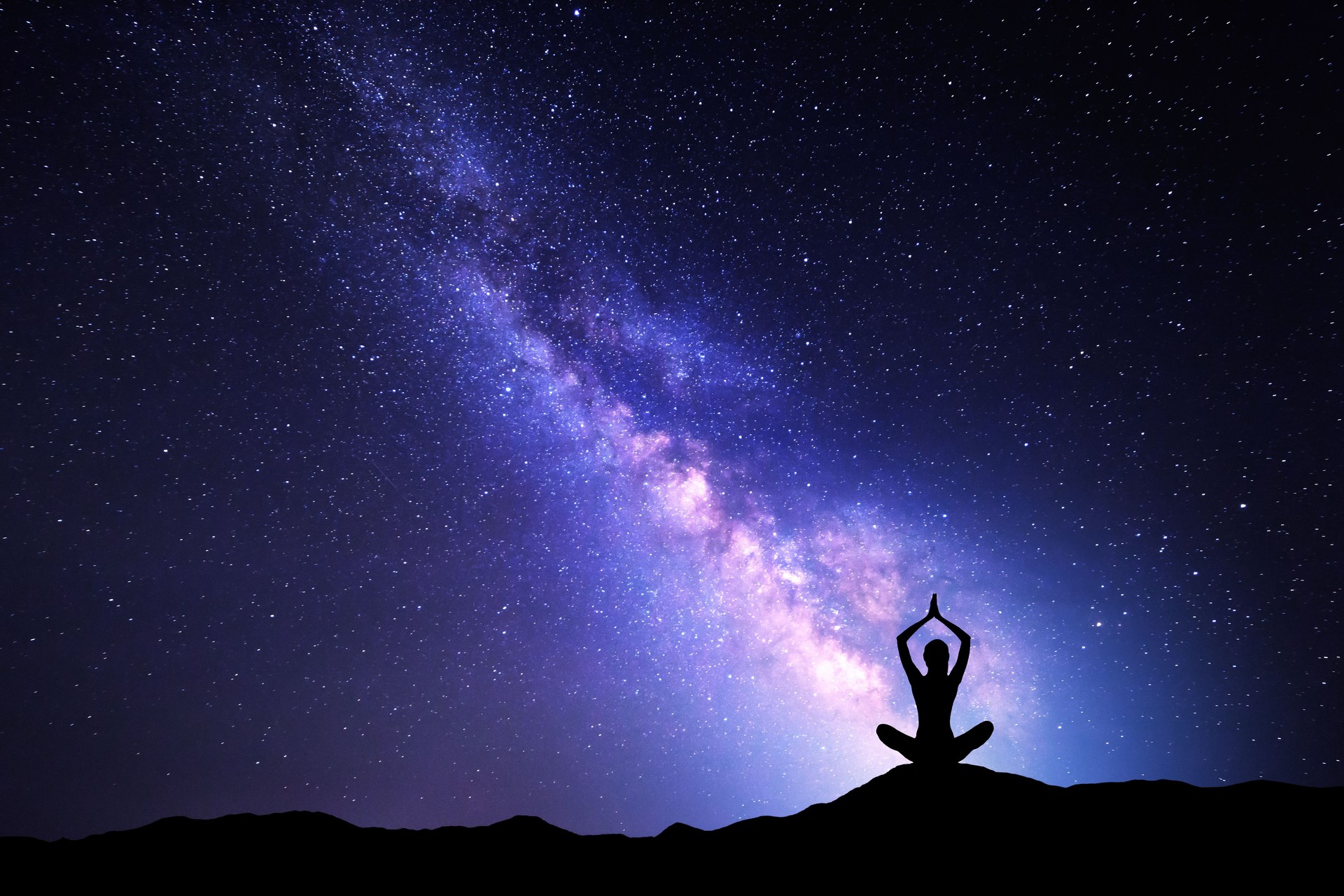 Milky Way and silhouette of a woman practicing yoga