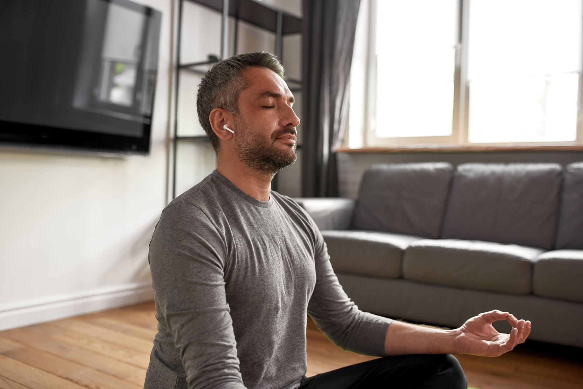 Calm man with eyes closed meditate at home